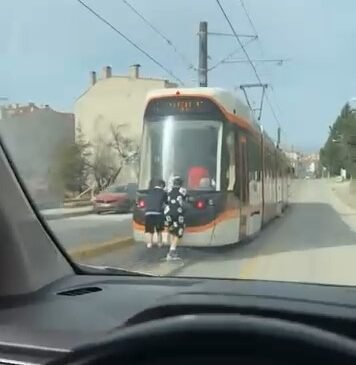 Tramvayın arkasına tutunan patenli çocukların tehlikeli yolculuğu