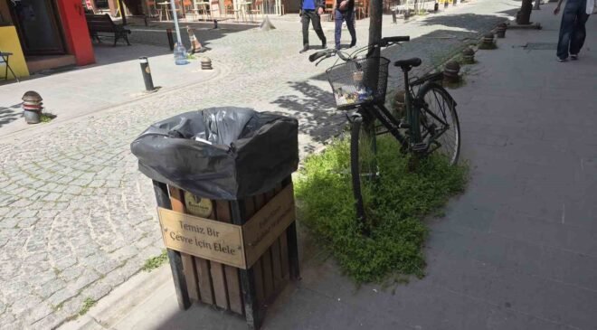 Çöp kutusunun hemen yanındaki bisikletin sepeti atıklarla doldu