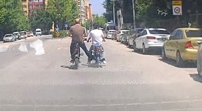 Bisiklet ile motosikleti ayağı ile iterek ilerletti